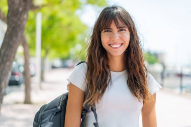 Açık havada genç bir kadın Neşeli bir ifadeyle