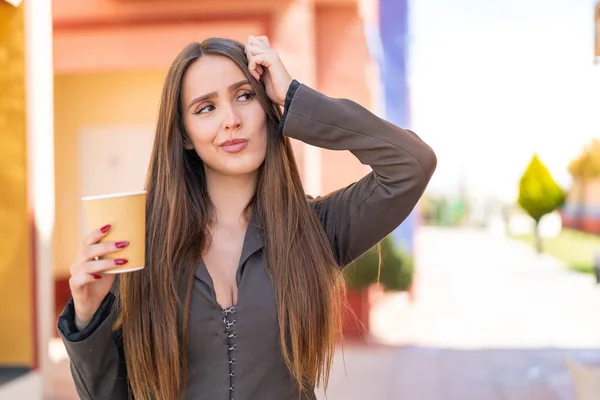 Ung Kvinna Som Håller Take Away Kaffe Utomhus Har Tvivel — Stockfoto
