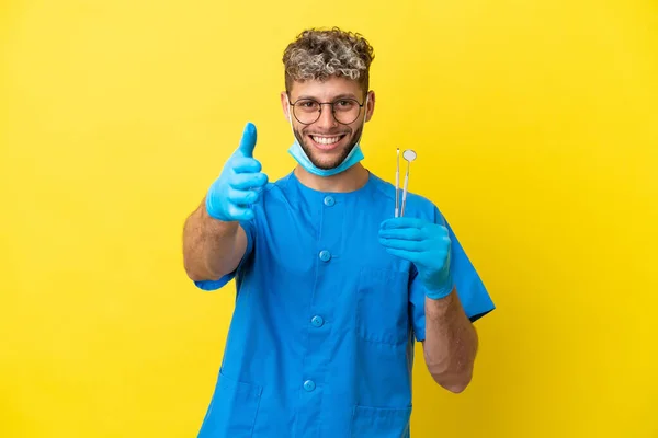 Dentista Caucasiano Homem Segurando Ferramentas Isoladas Fundo Amarelo Apertando Mãos — Fotografia de Stock