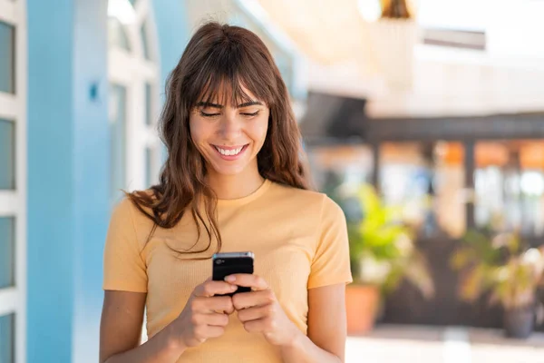 Dışarıdaki Genç Kadın Cep Telefonuyla Mesaj Posta Yolluyor — Stok fotoğraf
