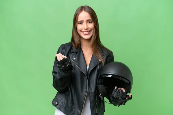 若いです可愛いですCaucasian女性とともにオートバイヘルメット上の隔離された背景メイキングお金ジェスチャー — ストック写真