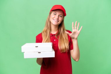 İş üniformalı beyaz pizzacı kadın izole edilmiş arka planda pizza kutularını topluyor parmaklarıyla beşi sayıyor.