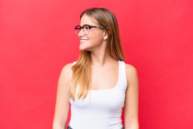 Kırmızı arka planda izole edilmiş genç ve güzel bir kadın.