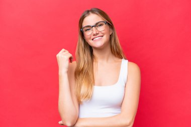 Genç ve güzel bir kadın kırmızı arka planda yalnız gülüyor.