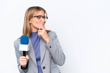 Genç TV sunucusu beyaz arka planda izole edilmiş beyaz kadın bir fikir düşünüyor ve bakıyor.