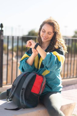 Genç bayan saatine bakıyor. 