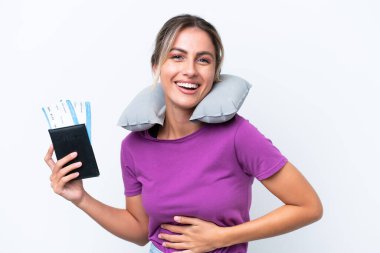 Şişirilebilir Seyahat Yastığı olan genç, güzel Uruguaylı kadın beyaz arka planda izole edilmiş, gülümsüyor.