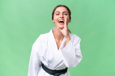 Genç Uruguaylı kadın tecrit edilmiş arka planda karate yapıyor ve ağzı açık bağırıyor