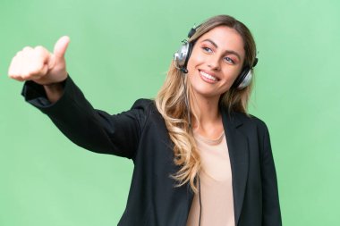 Tele pazarlamacı güzel Uruguaylı kadın tecrit edilmiş bir geçmişe sahip bir kulaklıkla baş parmak işareti yapıyor.