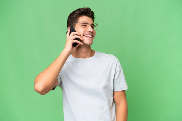 年轻的白种人英俊的男子与孤独的背景保持对话与手机 — 图库照片