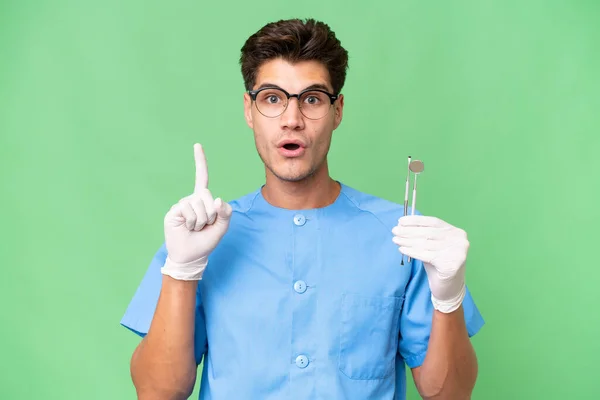 Jovem Dentista Homem Segurando Ferramentas Sobre Fundo Isolado Pensando Uma — Fotografia de Stock