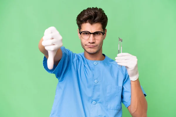Jovem Dentista Homem Segurando Ferramentas Sobre Fundo Isolado Mostrando Polegar — Fotografia de Stock