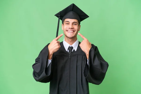 Νεαρός Απόφοιτος Πανεπιστημίου Καυκάσιος Άνδρας Πάνω Απομονωμένο Υπόβαθρο Χαμογελώντας Μια — Φωτογραφία Αρχείου