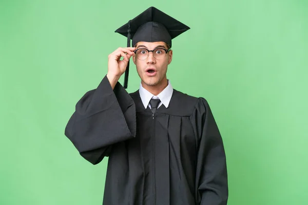 Jovem Universitário Graduado Caucasiano Homem Sobre Isolado Fundo Com Óculos — Fotografia de Stock