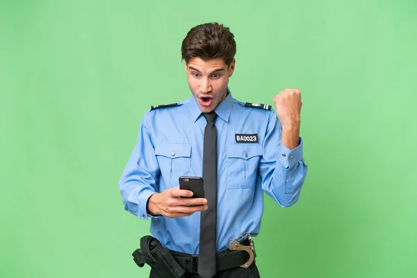 stock image Young police man over isolated background surprised and sending a message