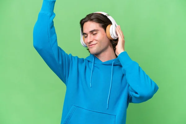 Jonge Knappe Man Geïsoleerd Groene Chroma Achtergrond Luisteren Muziek Dansen — Stockfoto