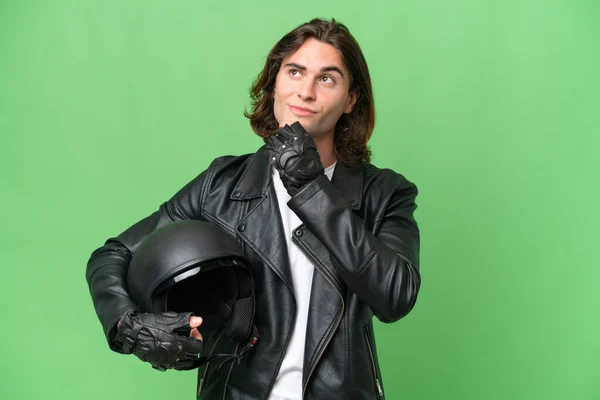 若いですハンサムな男とともにオートバイヘルメット隔離上の緑のクロマ背景と検索アップ — ストック写真