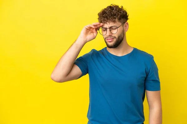 Stock image Young handsome caucasian man isolated on yellow background with tired and sick expression