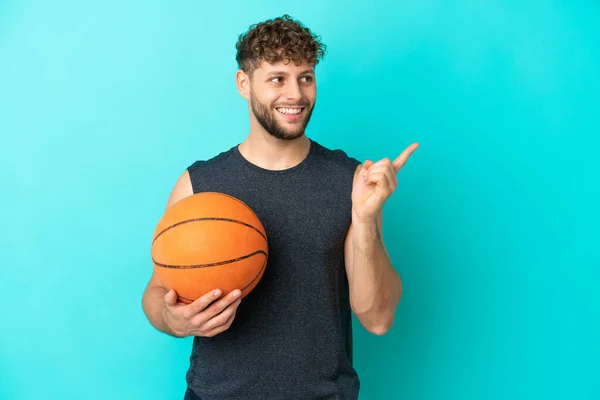 Pemuda Tampan Yang Bermain Basket Terisolasi Latar Belakang Biru Berniat — Stok Foto