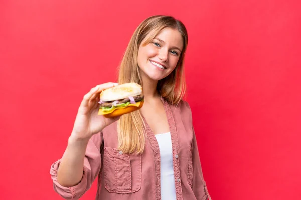 Young Caucasian Woman Holding Burger Isolated Red Background Happy Expression — Photo