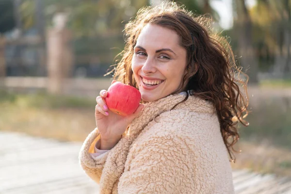 若いですCaucasian女性で屋外で食べるリンゴ — ストック写真