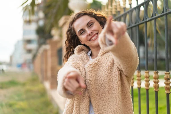 Joven Mujer Caucásica Aire Libre Señala Con Dedo Mientras Sonríe — Foto de Stock