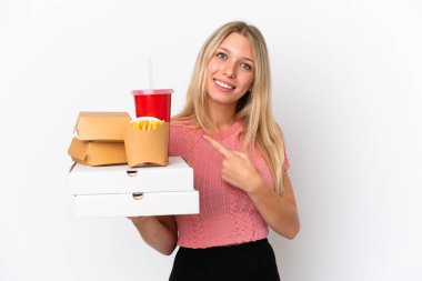 Mavi arka planda yağlı yiyecekler taşıyan beyaz bir kadın bir ürünü sunmak için yan tarafı işaret ediyor.