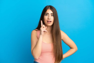 Kafkasyalı genç bir kadın mavi arka planda izole edilmiş.