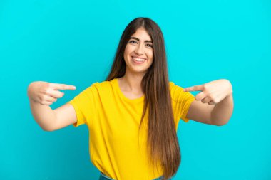 Mavi arka planda soyutlanmış, gururlu ve kendini beğenmiş beyaz bir kadın.