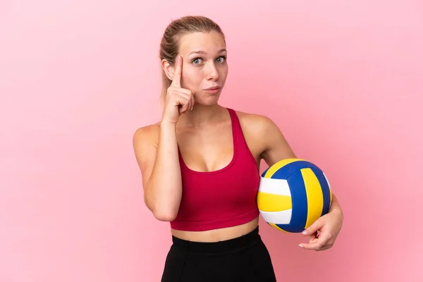 Молода Біла Жінка Грає Волейбол Ізольовано Рожевому Фоні Думаючи Про — стокове фото