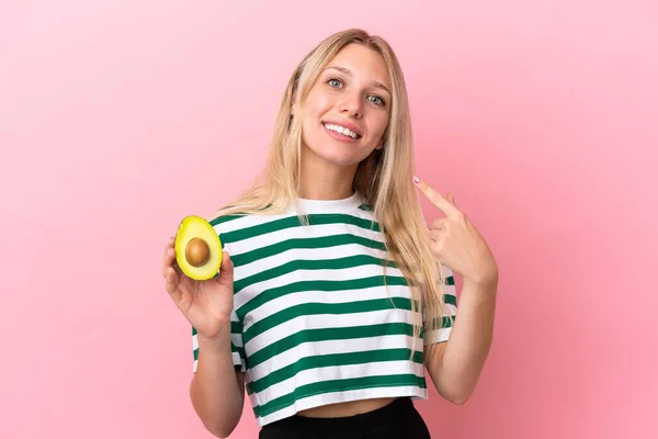 Young Caucasian Woman Holding Avocado Isolated Pink Background Giving Thumbs — Stock Photo, Image