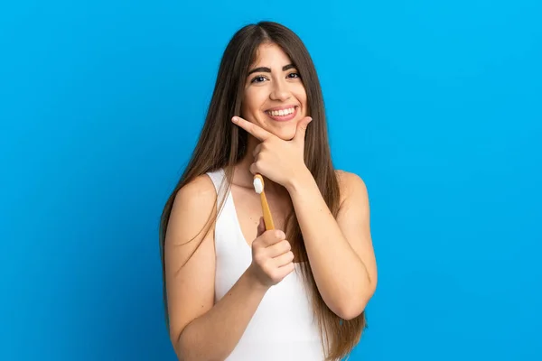 Młody Biały Kobieta Mycie Zęby Odizolowany Niebieski Tło Szczęśliwy Uśmiechnięty — Zdjęcie stockowe