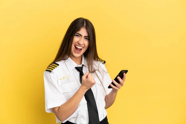 Repülőgép Pilóta Elszigetelt Sárga Háttér Telefon Győzelmi Pozícióban — Stock Fotó