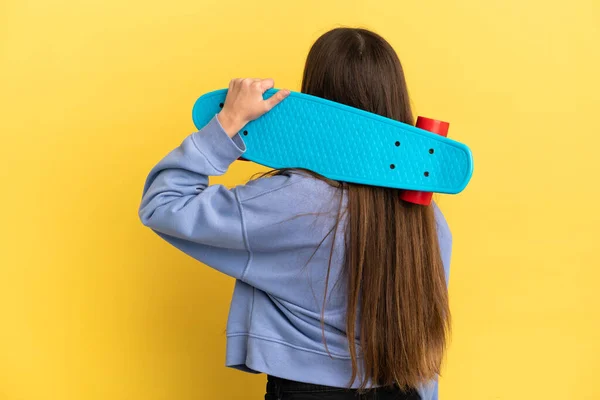 Mulher Caucasiana Jovem Isolado Fundo Amarelo Com Skate Posição Trás — Fotografia de Stock