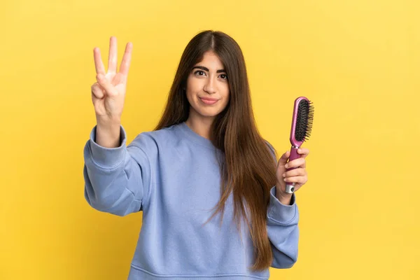 Mavi Arka Planda Saç Fırçası Tutan Beyaz Kadın Mutlu Parmaklarıyla — Stok fotoğraf