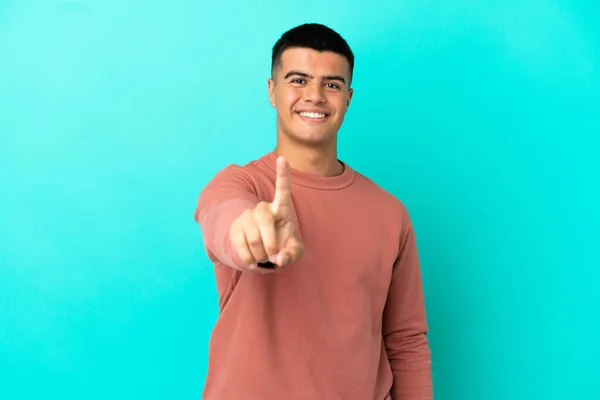 Mladý Pohledný Muž Přes Izolované Modré Pozadí Ukazující Zvedající Prst — Stock fotografie
