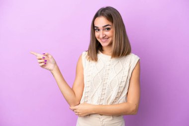 Mor arka planda izole edilmiş genç, beyaz bir kadın var.