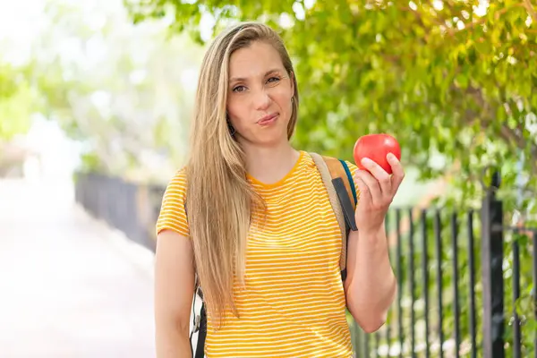 Junge Blonde Frau Mit Einem Apfel Freien Mit Trauriger Miene — Stockfoto
