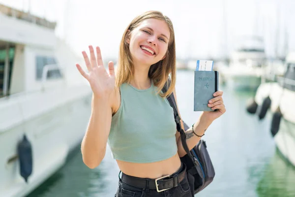 Jonge Blonde Vrouw Met Een Paspoort Buitenlucht Salueren Met Hand — Stockfoto