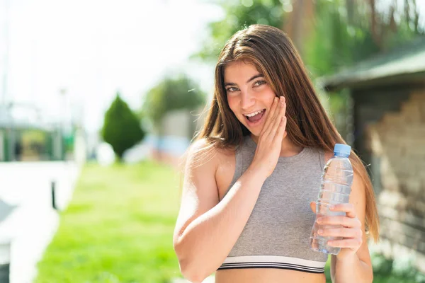 Jonge Blanke Vrouw Met Een Fles Water Buiten Fluisterend Iets — Stockfoto