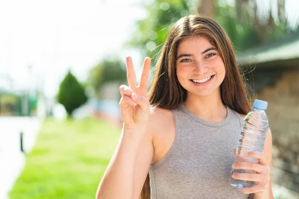Jonge Mooie Blanke Vrouw Met Een Fles Water Buiten Glimlachend — Stockfoto