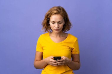 Genç Gürcü kadın, mor arka planda cep telefonu kullanarak izole edildi