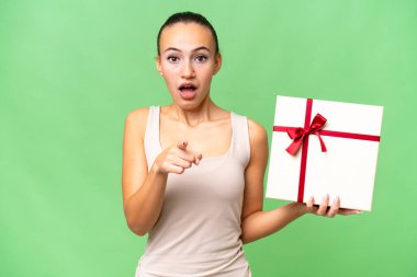 Genç bir Arap kadının, izole bir geçmişi var. Şaşırmış ve ön tarafı işaret ediyor.