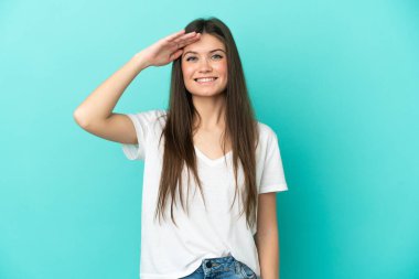 Mavi arka planda izole edilmiş beyaz bir kadın. Mutlu bir ifadeyle selamlıyor.