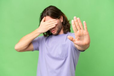 Tecrit edilmiş genç yakışıklı adam jesti durdurup yüzünü kapatıyor.