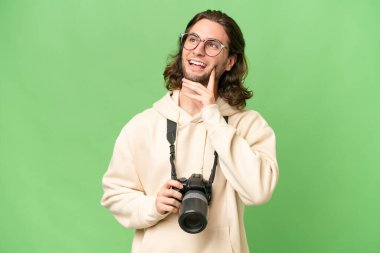 Genç fotoğrafçı, izole edilmiş arka planda bir fikir ararken...