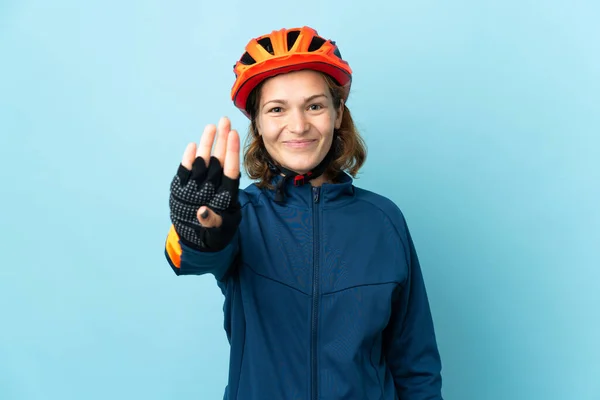 Молода Жінка Велосипедистка Ізольована Синьому Фоні Щаслива Рахує Чотири Пальцями — стокове фото