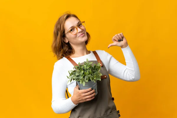 Young Georgian Woman Holding Plant Isolated Yellow Background Proud Self — Stock Photo, Image