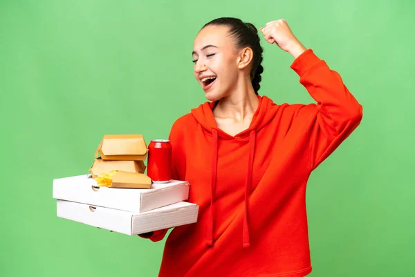 Giovane Donna Araba Che Tiene Fast Food Sfondo Isolato Celebrando — Foto Stock
