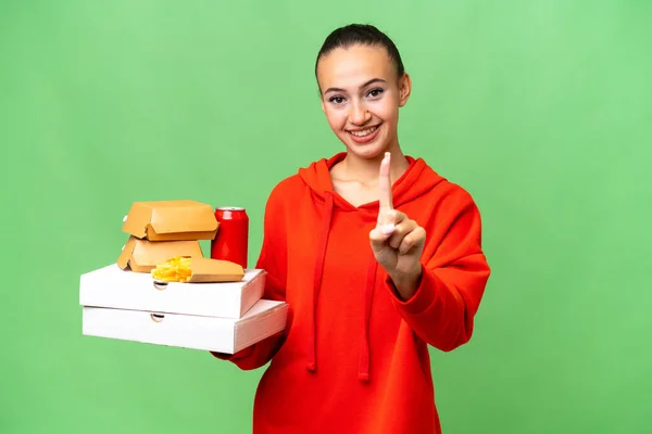 Young Arab Woman Holding Fast Food Isolated Background Showing Lifting — Stock Photo, Image